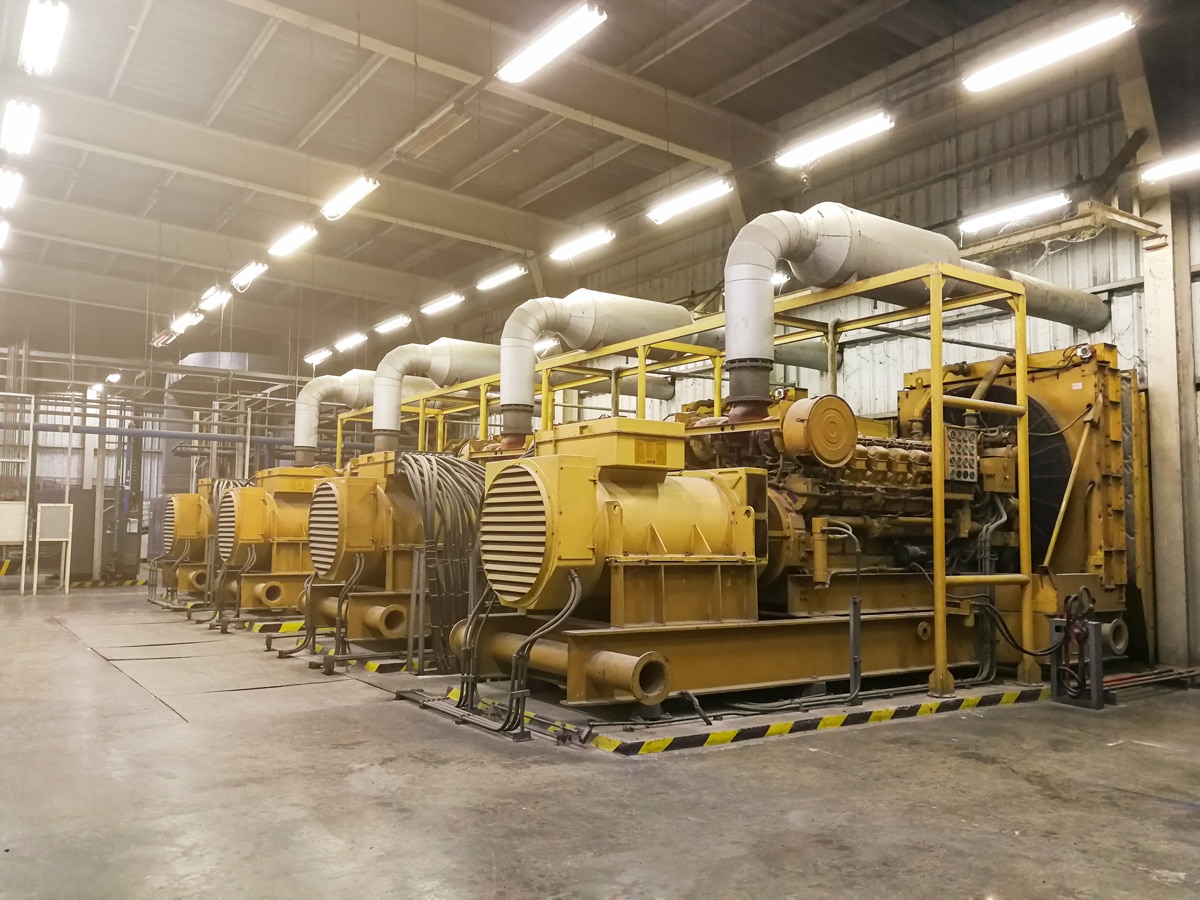 An El Paso warehouse that has four yellow generators in it.