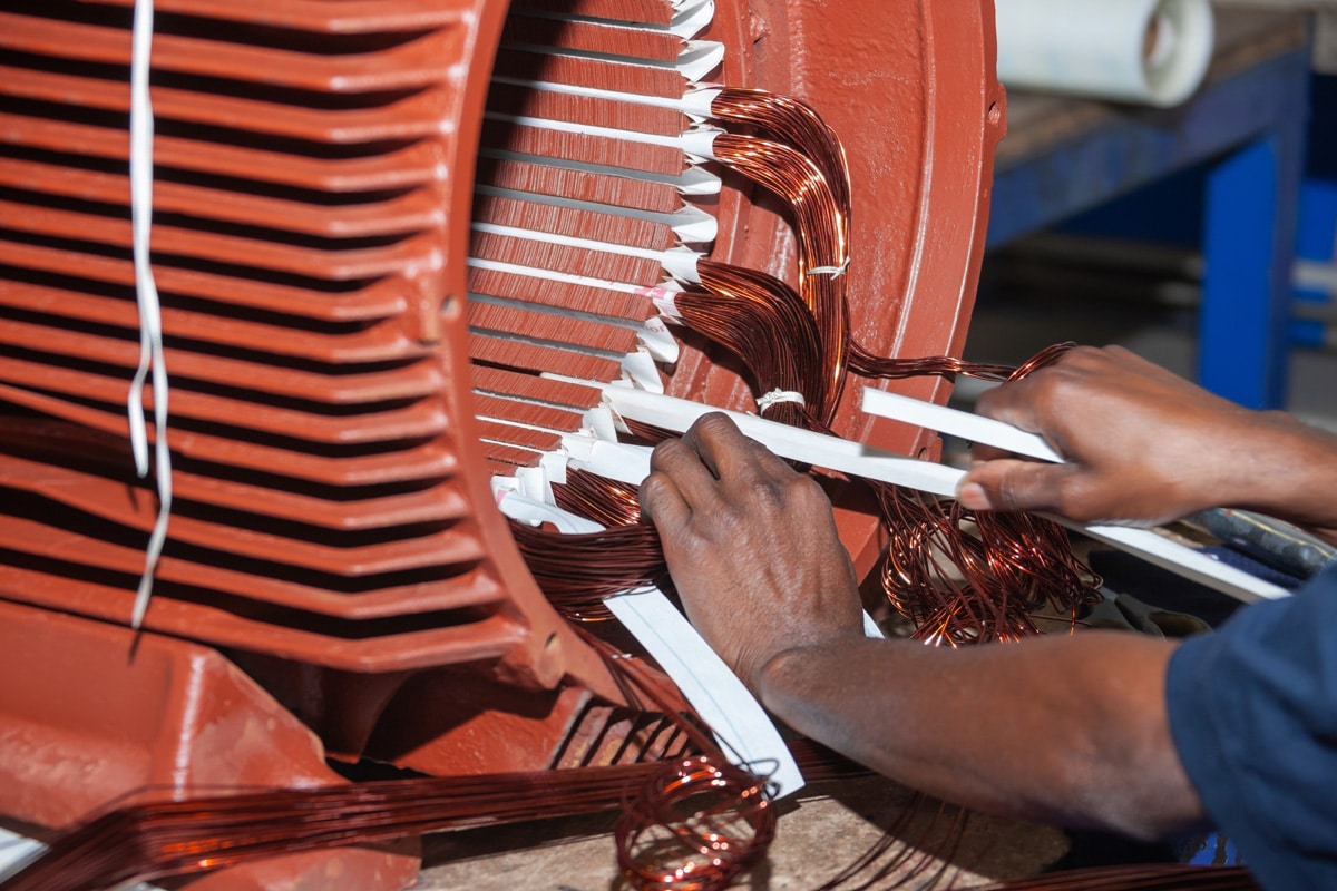 A professional rewinding a red electric motor in El Paso.